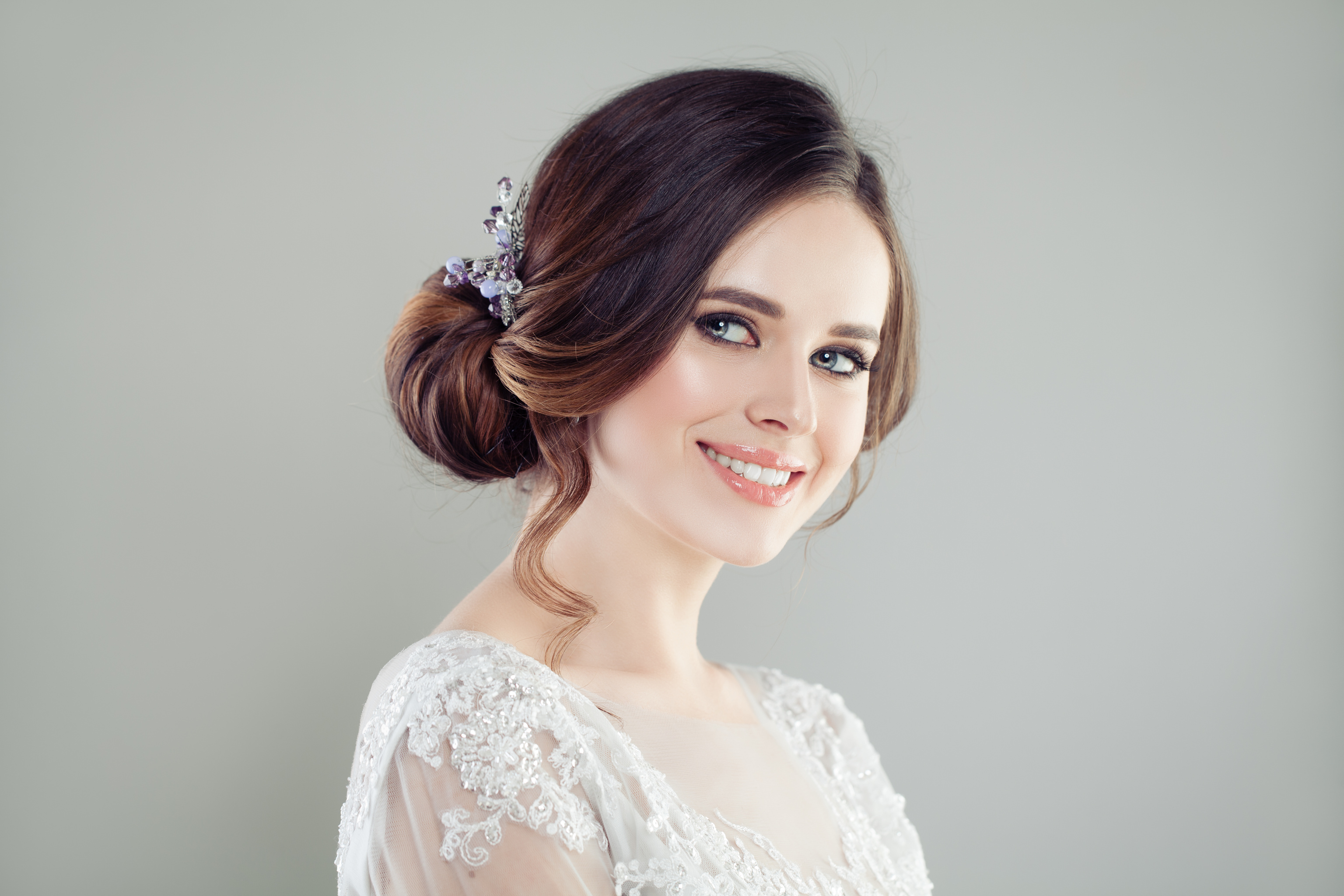 Smiling bride with makeup and updo hair bridal hairstyle